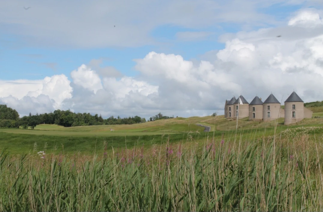Lough Erne Resort — a Faldo Course fairway with the resort's turreted lodges beyond