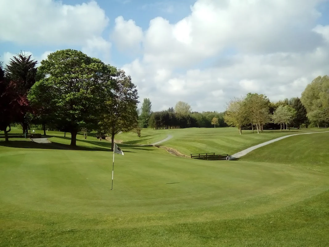 Malone Golf Club — a parkland green and stream on the Ballydrain course